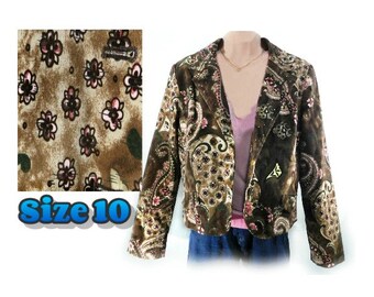 Könnte beinhalten: Ein brauner Blazer mit Paisley- und Blumenmuster. Die Jacke hat einen Reverskragen und lange Ärmel. Die Größe ist 10. Der Stoff hat eine Mischung aus braunen, rosa und cremefarbenen Farben.
