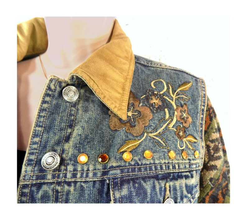 May include: A blue denim jacket with a brown corduroy collar, embroidered floral design, and gold-toned embellishments.