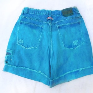 May include: Blue denim shorts with frayed edges and a distressed look. The shorts have a light blue wash and are made of a soft, comfortable fabric.