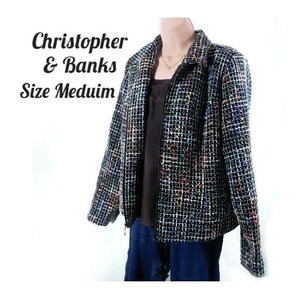 Può includere: Una giacca Christopher & Banks di taglia media con un motivo tweed nero, bianco e multicolore. La giacca ha una chiusura con cerniera e un colletto. Il testo "Christopher & Banks Size Medium" è visibile nell'immagine.