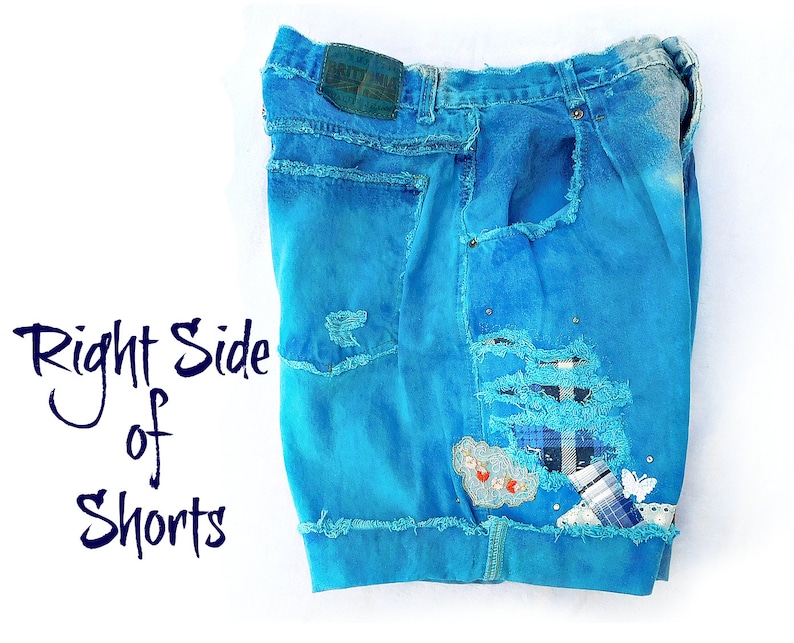 May include: A pair of blue denim shorts with distressed details and patches. The shorts have a light blue wash and are ripped and frayed around the edges. The text "Right Side of Shorts" is visible in the image.
