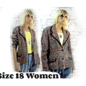 Può includere: Un blazer in tweed multicolore con finiture nere e due tasche anteriori. Il blazer è esposto su un manichino. Il testo "Size 18 Women" è nella parte inferiore dell'immagine.