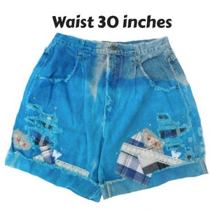 May include: Distressed denim shorts with a blue and white tie-dye pattern. The shorts have patches of fabric sewn on and are 30 inches in the waist.