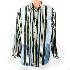 Puede incluir: Una camisa de manga larga con botones y rayas verticales en tonos de azul, negro y blanco.