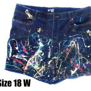 May include: Dark blue denim shorts with colorful paint splatter design. The shorts feature a button and zipper closure, pockets, and the text "terra sky". Size 18 W.