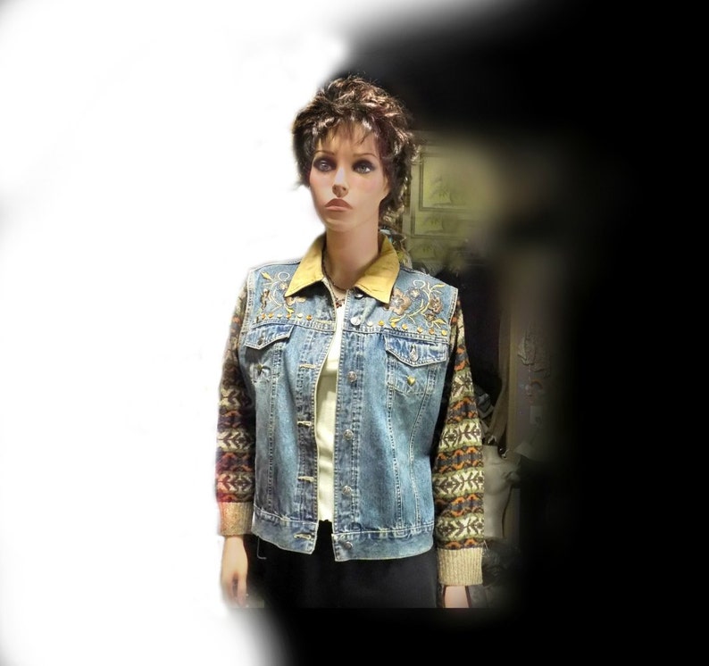 May include: A blue denim jacket with a brown suede collar and colorful embroidered sleeves. The jacket has a button closure and two front pockets.