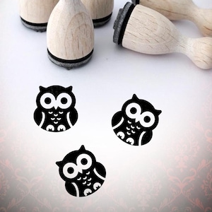 May include: Wooden stamps featuring owl designs. The stamps have a natural wood finish with a black rubber stamp base. Three black and white owl images are also visible. The text "Bloody Nose" is in the upper right corner.