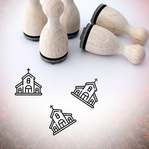 Könnte beinhalten: Satz mit fünf Holz-Stempeln mit einem Kirchenmotiv. Die Stempel sind rund und haben eine schwarze Basis. Das Kirchenmotiv ist einfach und schwarz.