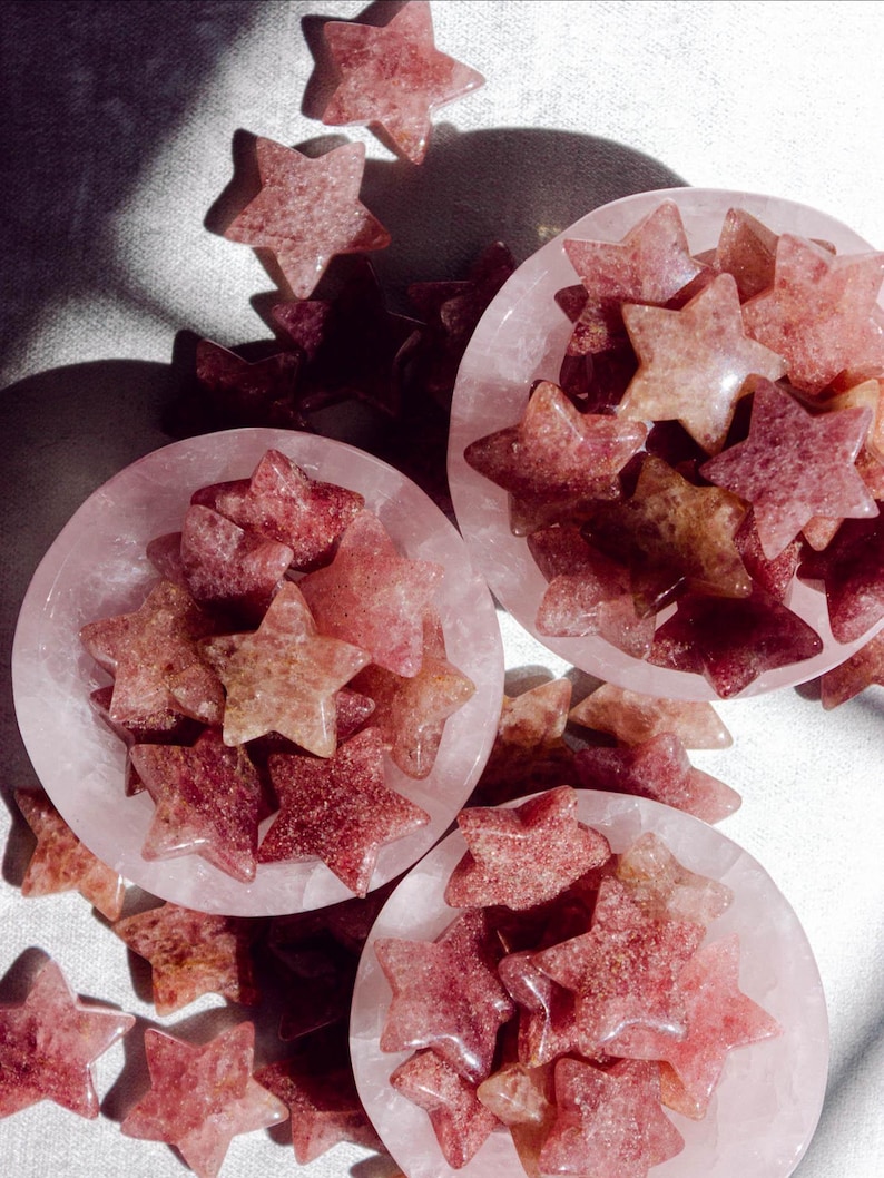 Strawberry quartz star crystals with natural pink and gold inclusions, sold as decorative healing stones to attract love, joy, and heart-centered energy.