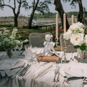 wedding reception table design with french blue silk ribbon tied around a white bust statue as a centerpiece