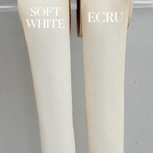 Op de afbeelding: Twee rollen lint, een met het label "SOFT WHITE" en de andere met het label "ECRU".