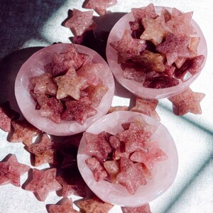 Strawberry quartz crystal stars displayed in rose quartz bowls, showing natural pink and red tones with a soft sparkle, perfect for crystal collectors, energy healing, or decorative use.