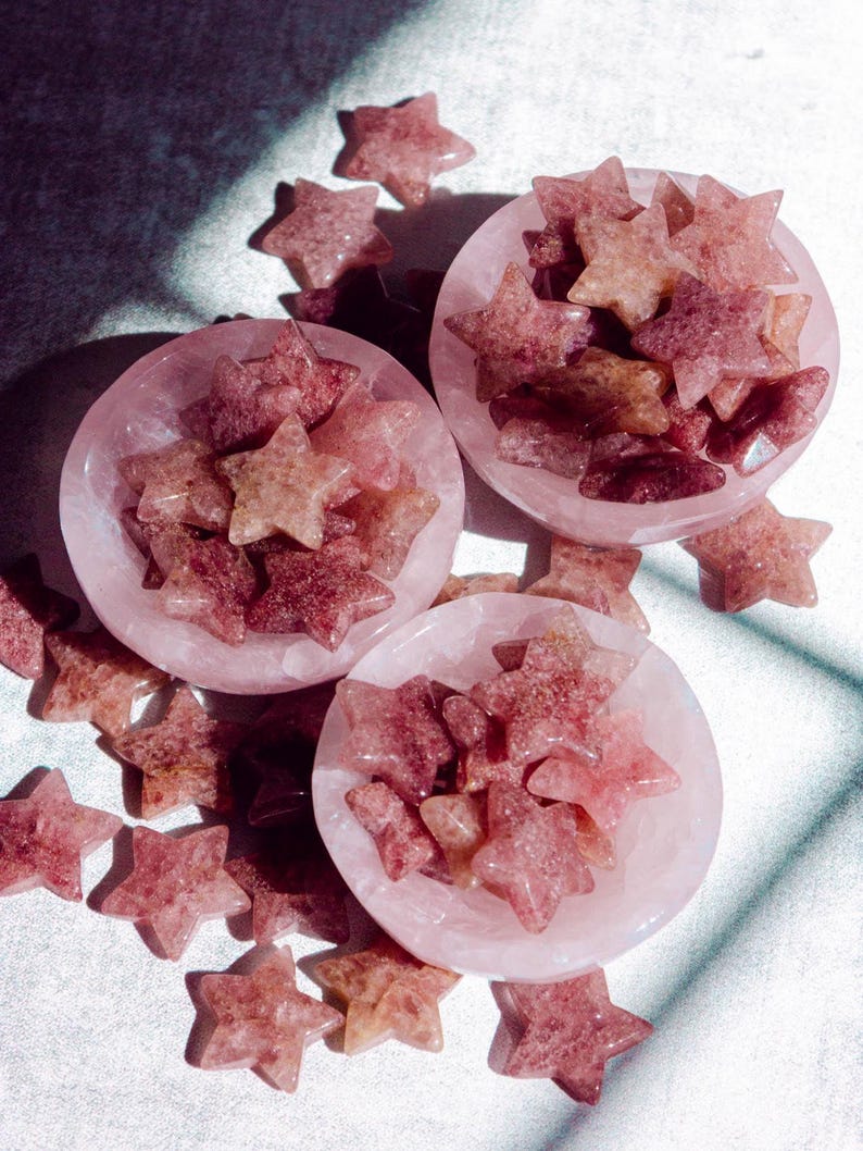 Strawberry quartz crystal stars displayed in rose quartz bowls, showing natural pink and red tones with a soft sparkle, perfect for crystal collectors, energy healing, or decorative use.