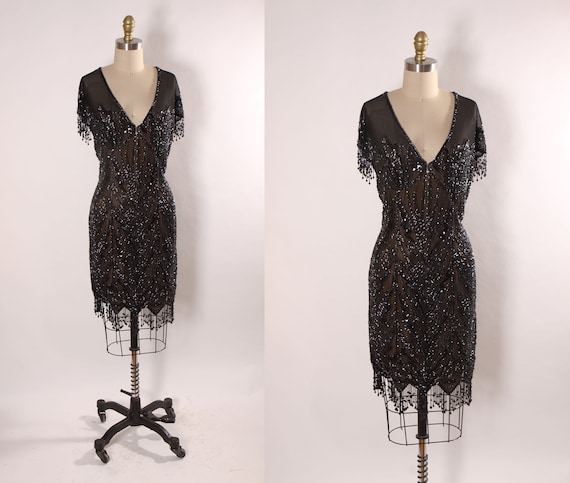 Late 1980s Early 1990s Black Sequin and Beaded Fringe Short Sleeve Flapper Style Sheer Nude Illusion Dress by Peak Evenings -M