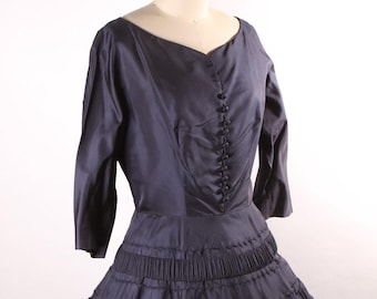 Vestido formal azul marinho estilo anos 50, manga 3/4, detalhes em botões, modelagem acinturada e evasê - M