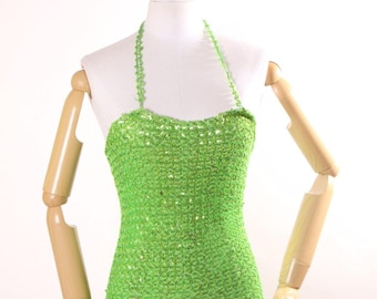 May include: A green sequined halter-style swimsuit with a crocheted design.