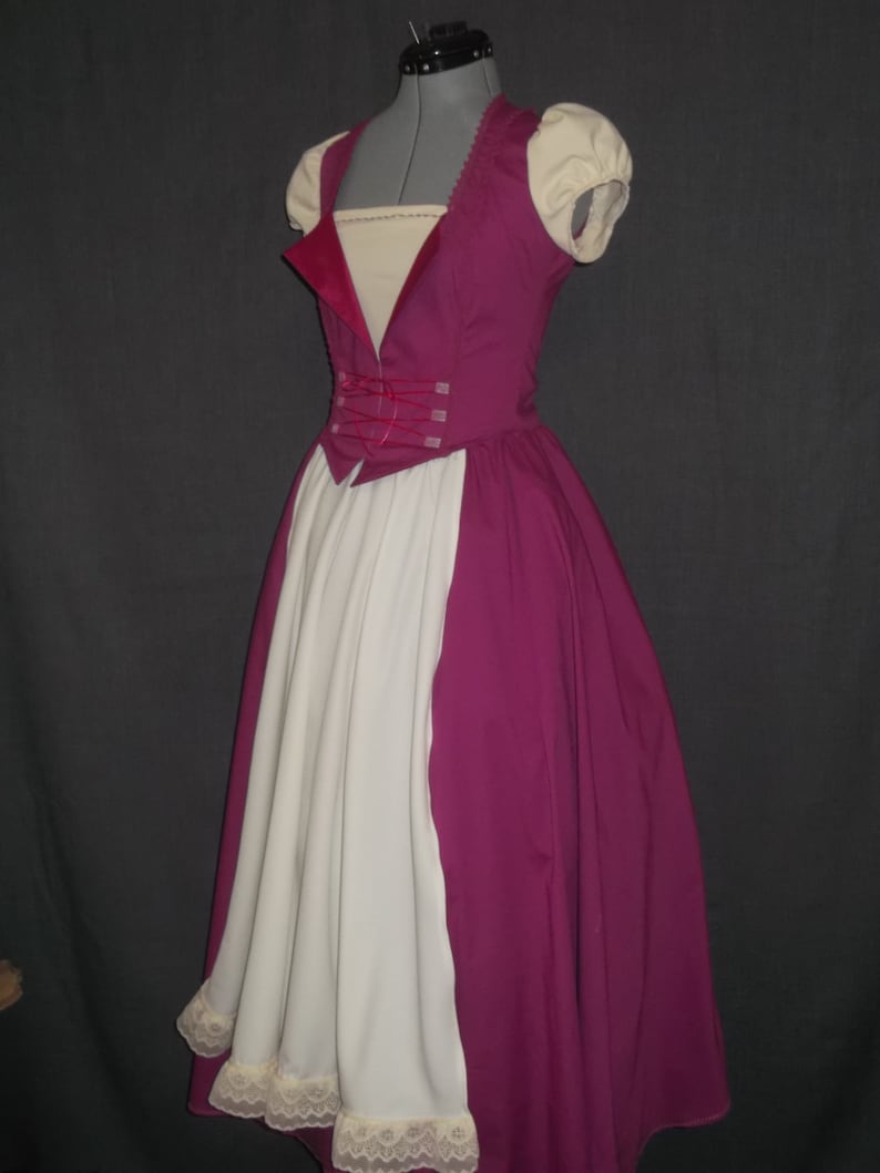 Puede incluir: Un vestido de disfraz magenta y blanco exhibido en un maniqu&iacute;. El vestido presenta un corpi&ntilde;o ajustado con cuello en V, mangas cortas color crema y una falda amplia. La falda blanca tiene un ribete de encaje en el dobladillo.