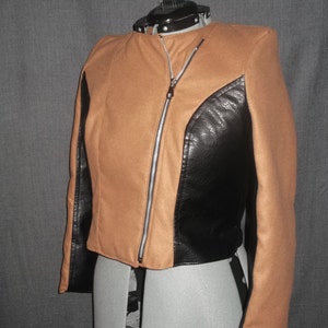 Puede incluir: Chaqueta marr&oacute;n y negra con cremallera diagonal. La chaqueta tiene un cuerpo marr&oacute;n con paneles negros de aspecto cuero en los laterales y las mangas. Se muestra en un maniqu&iacute;.