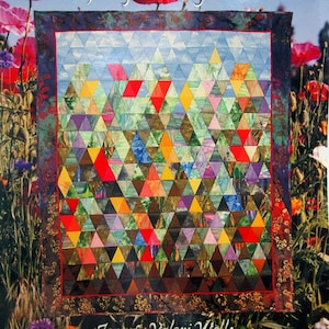 May include: A book cover titled "Everything Flowers, Quilts from the Garden" featuring a colorful quilt with triangular patterns. The quilt has red, yellow, blue, and green shapes. The background shows red flowers.