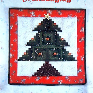 May include: A Christmas-themed wall hanging featuring a log cabin design of a Christmas tree. The tree is made of dark green and brown fabric, with a gold star on top. The wall hanging is framed with a red border and is displayed above a fireplace.