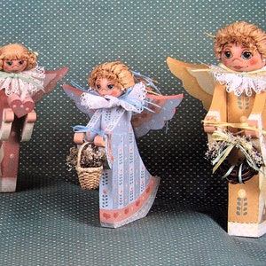 May include: Four wooden angel figurines with painted details. Each angel has wings, a dress, and a different accessory. The angels are painted in shades of blue, pink, and yellow.