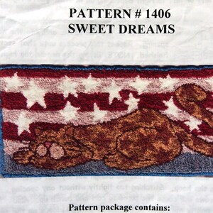May include: A punch needle embroidery pattern for a rug featuring a sleeping cat with stars on a red, white and blue background. The pattern is titled "Sweet Dreams" and is number 1406. The pattern package includes a stamped design on fabric, a colour picture and guide with step-by-step instructions, a floss list, and Russian punch needle facts.