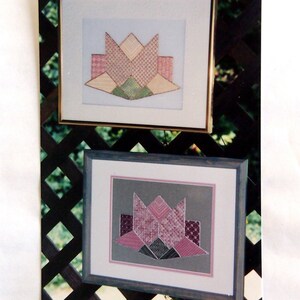 May include: Two framed quilt blocks with a spring fling theme. The blocks are made of pink, green, and yellow fabric and feature a flower design. The frames are gold and have a white mat.