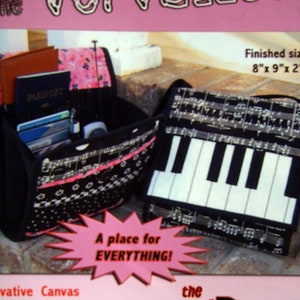 May include: A black and white fabric bag with a musical note design. The bag is open and shows a passport, credit cards, and a mobile phone. The bag is 8 inches by 9 inches by 2 inches. The bag is called "The Baos with Panache Collection".