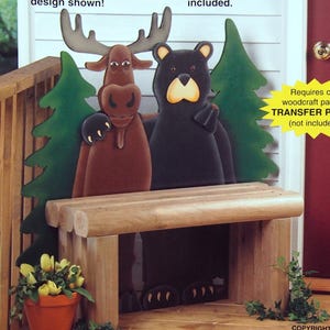 Könnte beinhalten: Eine Produktverpackung für ein Northern Pals Bench Holzarbeitsmuster. Das Bild zeigt eine Holzbank mit Ausschnitten eines braunen Elchs und eines schwarzen Bären dahinter. Der Text enthält Full Size Woodcraft Patterns, The Winfield Collection und Maße von 106,7 cm Höhe und 86,4 cm Länge.