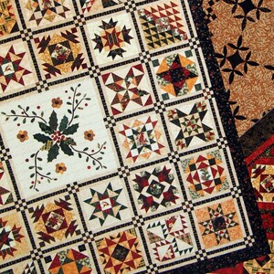 May include: A wooden background with the title "Four Seasons at Minglewood" and the author's name, Debbie Roberts. The image displays three quilts with star and floral patterns in various colours, including red, green, and beige.