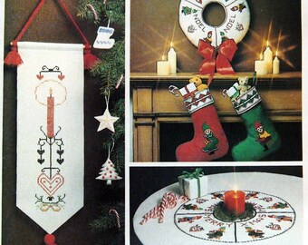 Könnte beinhalten: Ein Vintage-Stickmuster für skandinavische Weihnachtsdekorationen. Das Muster umfasst ein Banner, einen Kranz, einen Strumpf, einen Baumrock und mehrere Ornamente. Das Muster ist auf weißem Hintergrund mit roten, grünen und weißen Akzenten gedruckt.