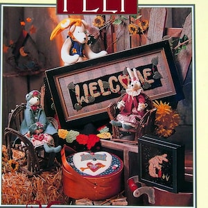 May include: A book cover with a yellow background and red polka dots. The title is "Folk Art Felt" with a red heart on each side. The cover features a variety of felt crafts, including a welcome sign, a bunny, a bear, and a basket. The text on the cover reads "36 Heartfelt Projects with Creative New Embellishments by Sandy Belt."