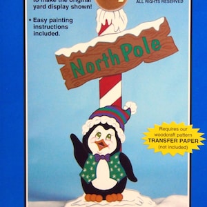 May include: A blue pattern package for a North Pole Penguin sign. The sign features a penguin wearing a hat and vest, standing next to a sign that reads "North Pole". The pattern is 51 inches tall.