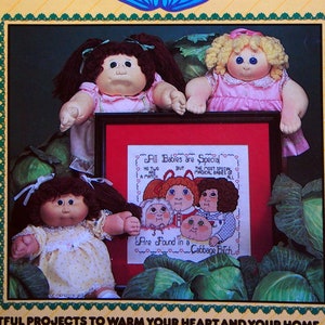 Puede incluir: Un libro de patrones de punto de cruz con muñecas Cabbage Patch Kids. La portada presenta una ilustración colorida del logotipo de Cabbage Patch Kids y un grupo de muñecas. El libro incluye el texto "Todos los bebés son especiales, pero no hay dos iguales. Los bebés más especiales, los bebés mágicos, están todos en un campo de coles."