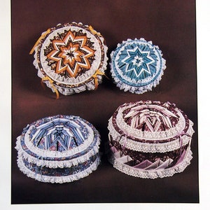 Peut inclure: Quatre boîtes rondes en métal décorées d'étoiles en tissu plié. Les boîtes sont de tailles et de couleurs différentes, notamment orange, bleu et violet. Le texte "FOLDED STAR DECORATOR TIN" est en haut de l'image. Le texte "NO SEWING REQUIRED" est sous les boîtes. Le texte "Fast - Easy - Fun." est sous le texte "NO SEWING REQUIRED". Le texte "Excellent sewing or Embroidery kit!" est à droite de l'image. Le texte "Manicure storage." est sous le texte "Excellent sewing or Embroidery kit!"