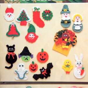 May include: A selection of crocheted fridge magnets in festive designs, such as Santa, a Christmas tree, a stocking, a wreath, a snowman, a pilgrim, a turkey, a black cat, a witch, pumpkins, a bat, a ghost, a chick, a bunny, shamrocks, a flag, and hearts. The text "HOLIDAY 'FRIDGIES' to crochet" is visible.