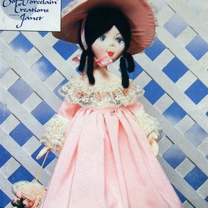 May include: A vintage sewing pattern for a porcelain doll with a pink dress and a white lace trim. The doll is wearing a pink hat with a white lace trim. The pattern is from Butterick and is number 392. The pattern is for a craft project.