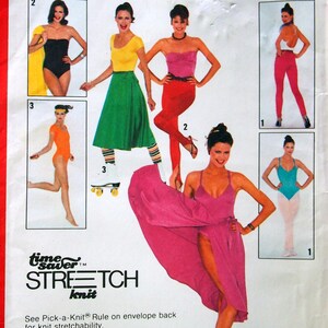 May include: Simplicity 9271 sewing pattern with illustrations of women's clothing designs. The pattern shows a black swimsuit, a yellow top with a green skirt, and a pink dress. The text on the pattern reads "STRETCH knit".