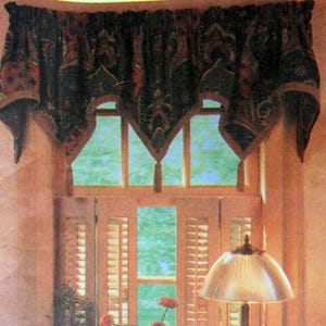 May include: A Simplicity Easy Basics pattern for a window valance. The valance is dark with a paisley design and a scalloped edge. The image also shows a window with shutters and a lamp.