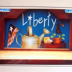 May include: A framed painting with a blue background and the word "Liberty" written in white. The painting also features a watering can, a small plant, and an American flag.