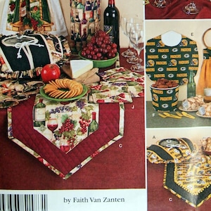 May include: A sewing pattern for a variety of home decor items, including a wine bottle holder, a table runner, a bread basket cover, and a set of wine glass charms. The pattern includes instructions for making each item, as well as a list of materials needed. The pattern is designed by Faith Van Zanten and is available on the website www.simplicity.com.