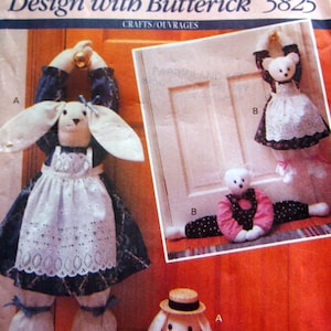 May include: A vintage sewing pattern for making doorstop bunny rabbits. The pattern is from Butterick and is number 5825. The pattern shows three different bunny designs, one with a white apron, one with a pink and black polka dot dress, and one with overalls.