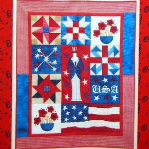 May include: A patriotic quilt with red, white, and blue patchwork. The quilt features stars, flowers, and the word "USA". The image includes the text "pieces from my heart" and "#333 Democracy".