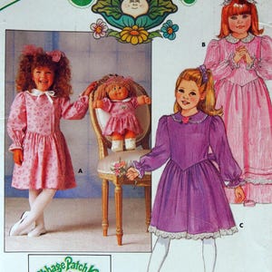 May include: A vintage Butterick sewing pattern for Cabbage Patch Kids outfits. The pattern features illustrations of children's dresses in pink and purple, with a Cabbage Patch Kids logo and the size range (5-6-6X). Includes iron-on transfers.