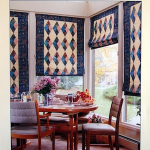May include: A book cover titled PIECED ROMAN SHADES Turn Your Favourite Quilt Patterns into Window Hangings by Terrell Sundermann. The cover features a photograph of a dining room with windows covered by diamond-patterned fabric shades.