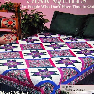 May include: Book cover for "Weekend Star Quilts" by Marti Michell. The book is part of the "Quilting for People Who Don't Have Time to Quilt" series. The cover features a quilt with a star pattern in shades of pink, purple, blue, and white. The quilt is on a bed with a green headboard. The book title is in white text on a pink background. The book subtitle is in black text on a pink background. The author's name is in white text on a black background. The book cover also includes a photo of a sewing machine and a close-up of the quilt blocks.