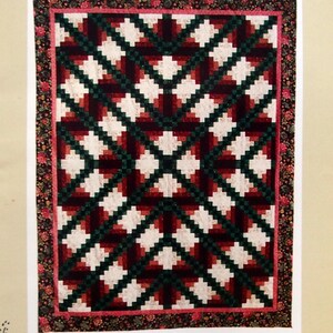 May include: A quilting pattern for an Irish Cabin quilt in queen or king size. The pattern features a geometric design with red, green, and white squares. The pattern is titled "Irish Cabin" and is from Prairie's Edge Patchworks.