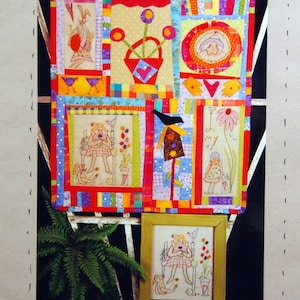 Peut inclure: Une courtepointe colorée avec des motifs d'art populaire, dont une fille, des fleurs et un nichoir. La courtepointe mesure environ 71 cm x 81 cm. L'image montre également une broderie encadrée du même motif. Le texte indique "ANGIE HAD A GARDEN".