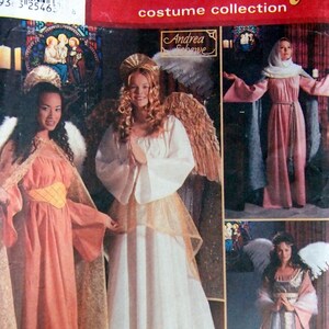May include: Simplicity Holiday costume collection sewing pattern featuring three angel costumes. The pattern includes a pink angel costume with gold trim, a white angel costume with gold trim, and a pink and gold angel costume with a halo.