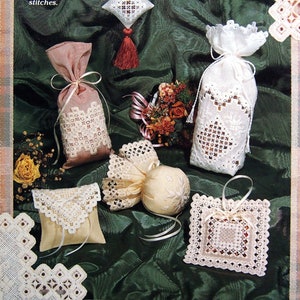 Peut inclure: Divers sachets en dentelle faits à la main de différentes formes, dont un ornement en forme de losange avec un pompon et un petit coussin. Les sachets sont présentés sur un fond de tissu vert. Le texte indique : "Créez six sachets en dentelle tout en pratiquant et en perfectionnant les points."